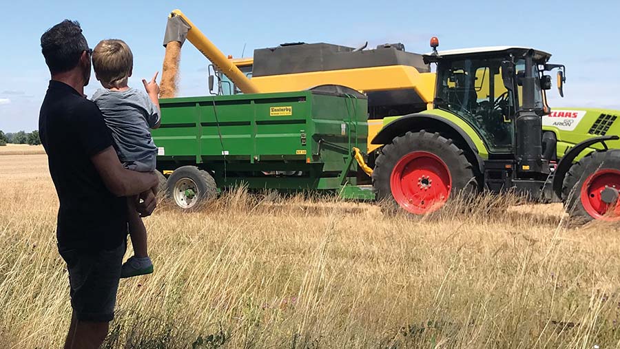 Neil Worby and grandson in field with harvest machinery