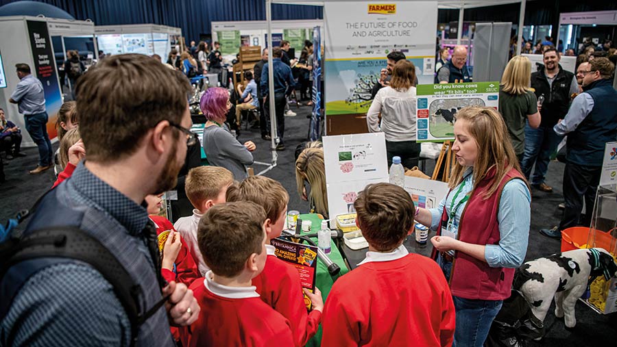 Children crowd around an exhibit and New Scientist Live