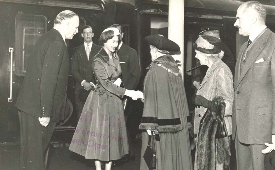 Old picture of the Queen shaking hands with a man