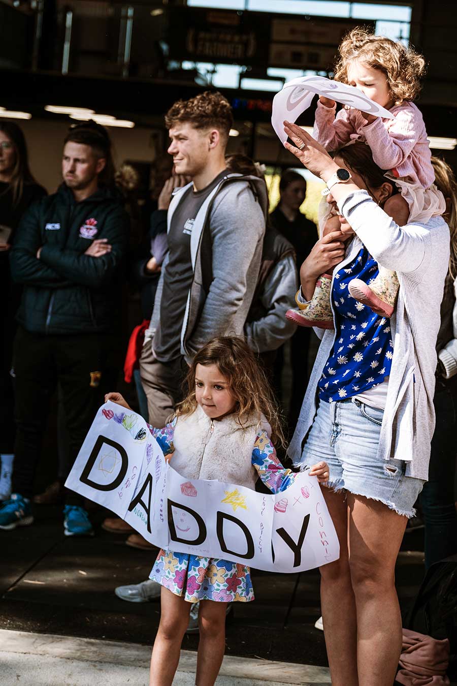 Young girl with "Daddy" banner