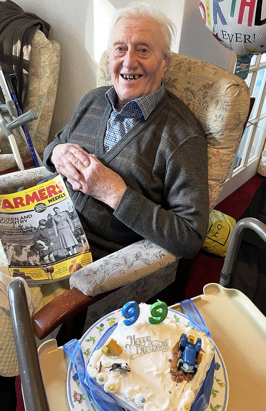 Farm grandad with his birthday cake and copy of Farmers Weekly