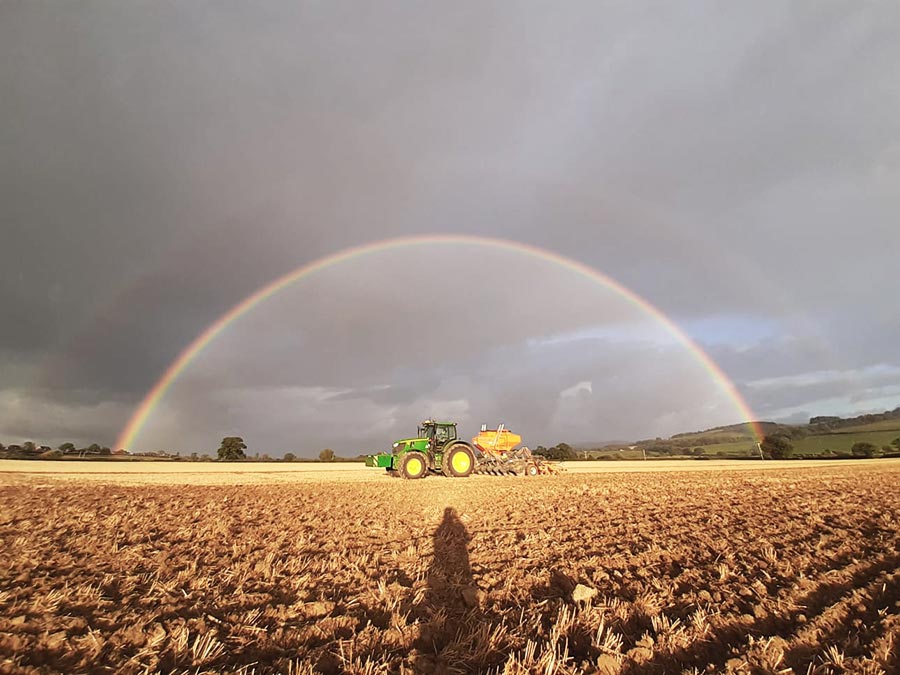 Mzuri Pro-til drill working in field with a rainbow in the sky