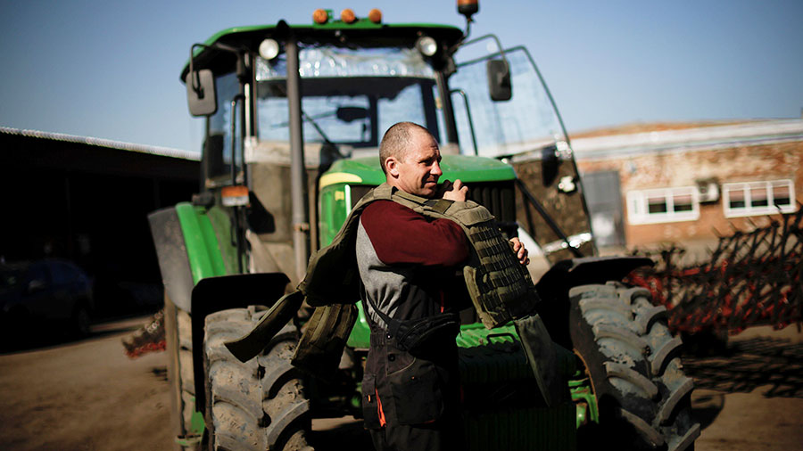 A Ukrainian farmer dons body armour in preparation to work in the field © AlamyStock/REUTERS/Ueslei Marcelino