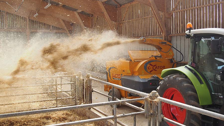 Bale chopper throwing bedding into pens