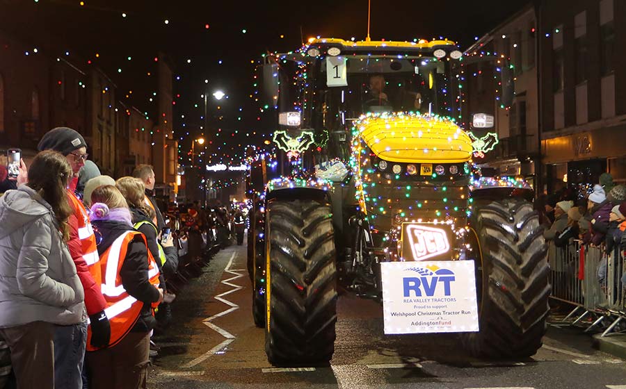 Tractor in Welshpool town with crowds looking on 