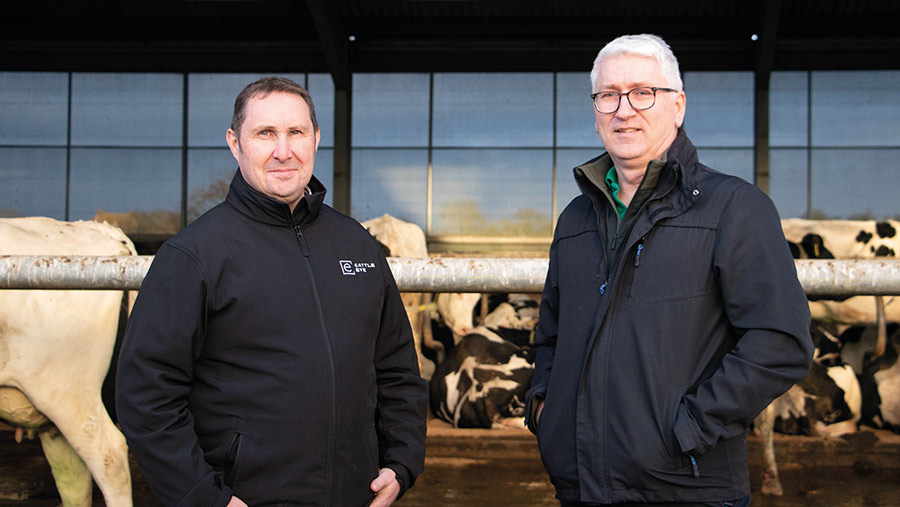 Two men standing outside a cattle shed