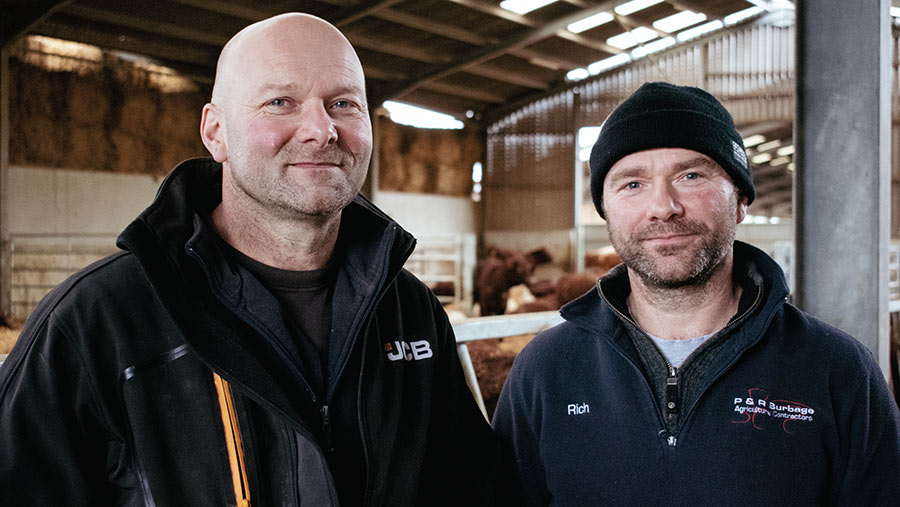 Two men inside a cattle shed