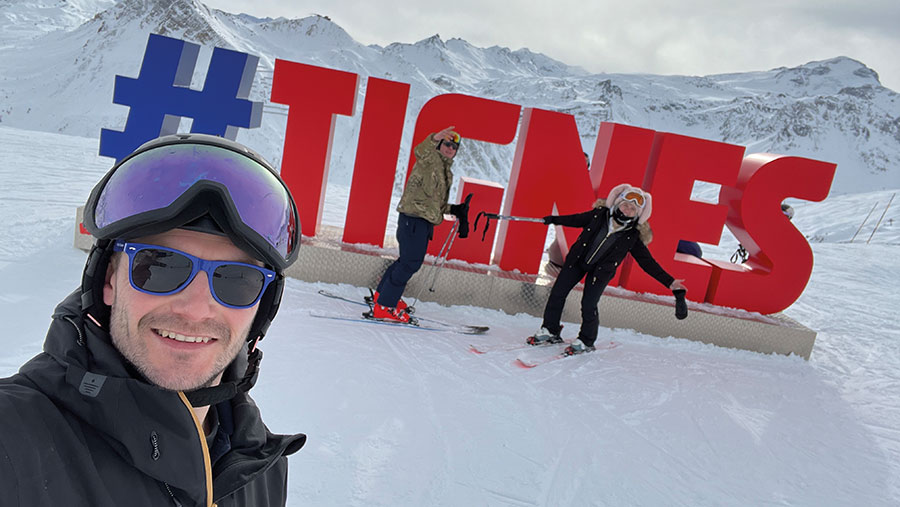 People posing on a ski slope with a giant #Tignes sign