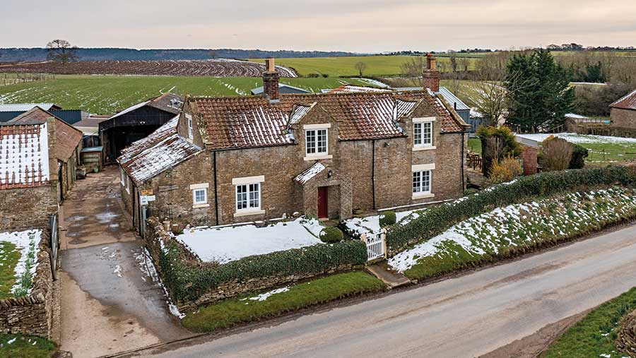 Aerial view of farmhouse with snow