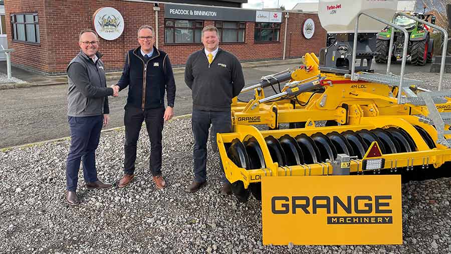 Three people in a dealer's yard with a cultivator