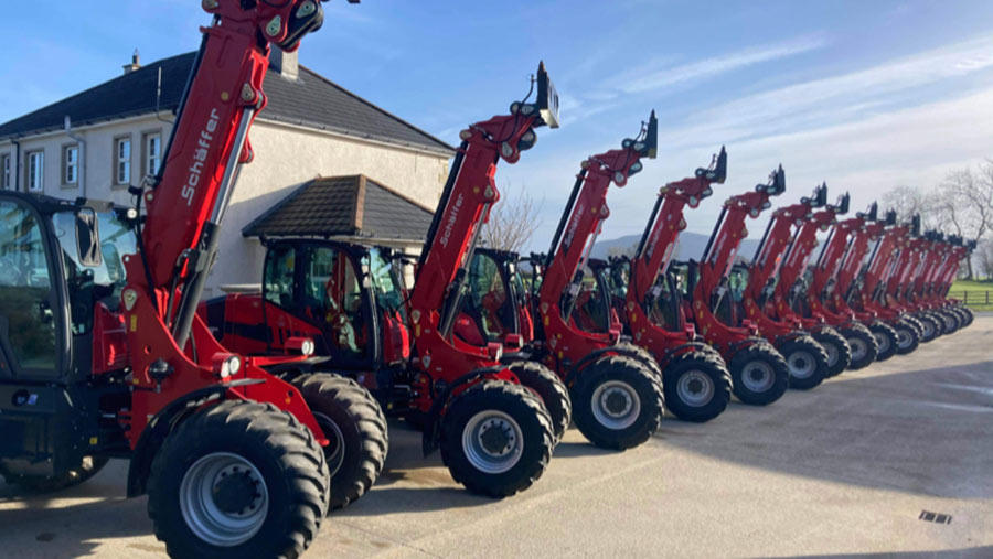 Row of telehandlers with their booms lifted