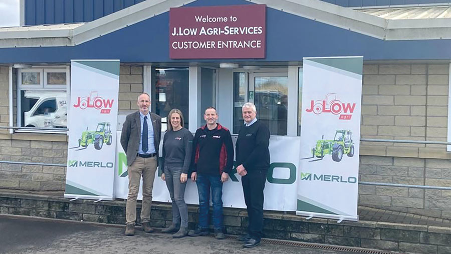 Four people pose outside a dealer's office