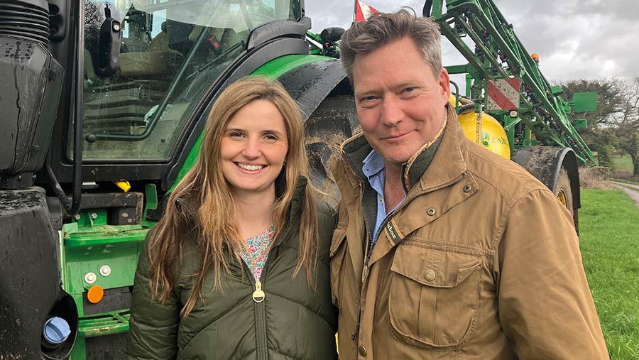 Couple standing in front of a tractor