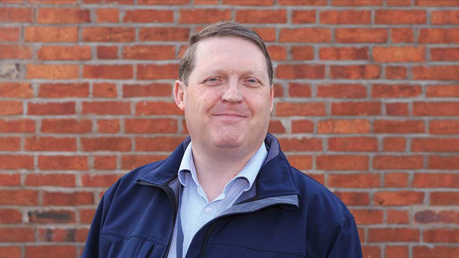 Man standing before a brick wall