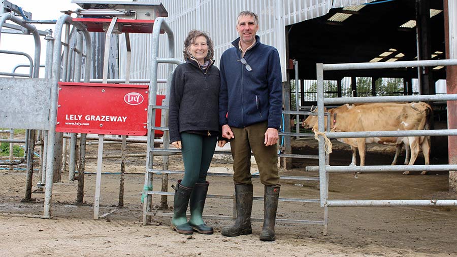 Rosie Sage and David Paull standing by lely milking robot