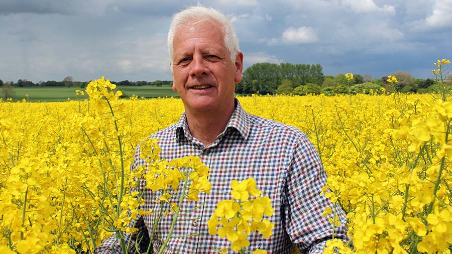 David Leaper standing in OSR field in flower