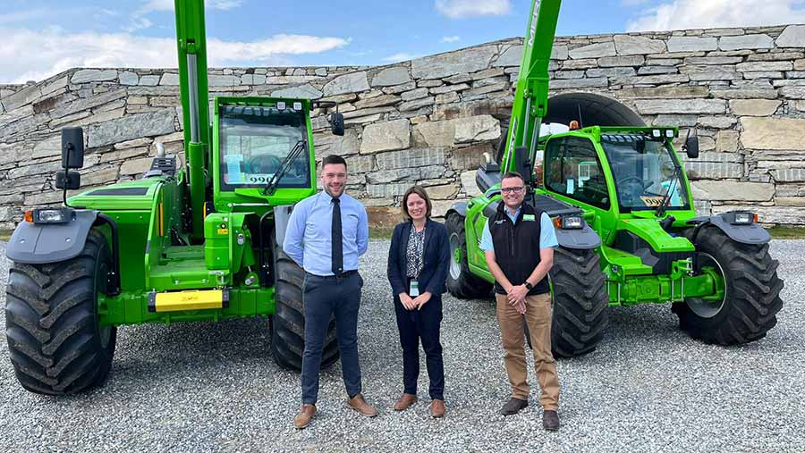 Three staff members with farm machinery