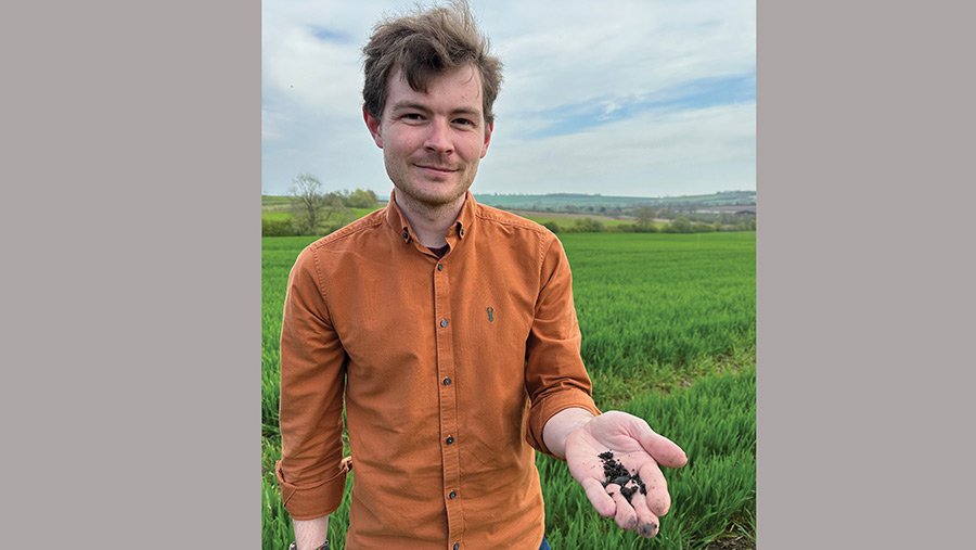 Dr Tom Bott holding a sample of biochar