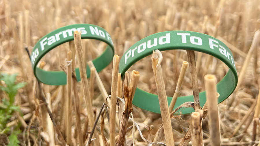 Wristbands with a 'Proud to Farm' slogan propped up in a field