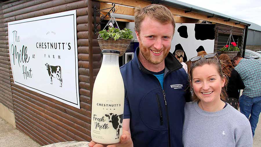 William and Alison Chesnutt, showing their farm-produced milk bottle outside their milk vending machine