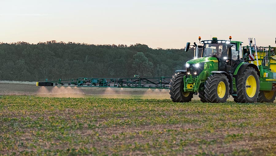 Tractor with spot-sprayer in a field