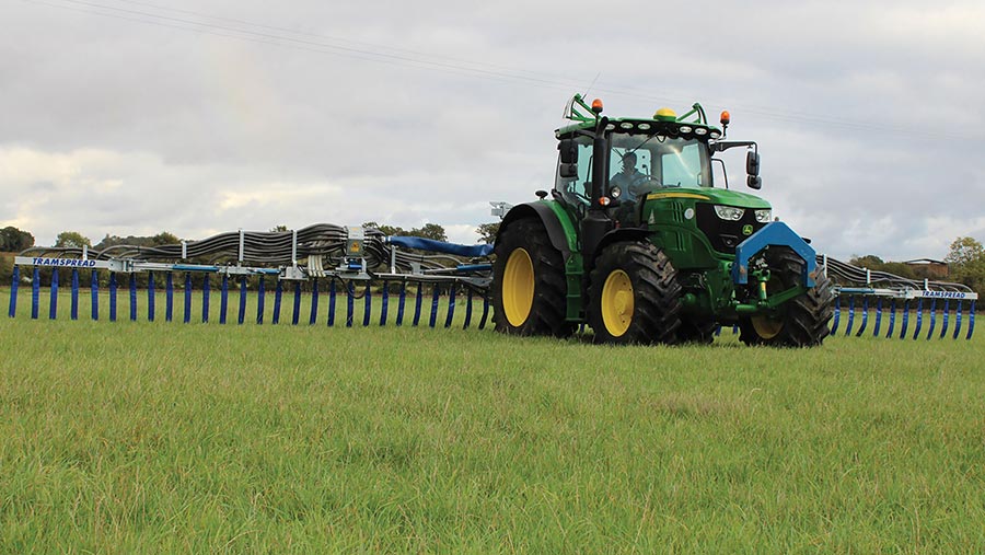 Dribble bar attached to a tractor in a field