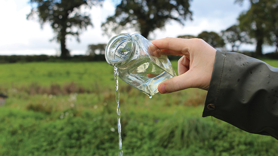 Clear water being poured from a jar