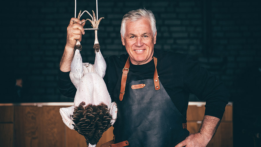 Man (Paul Kelly) holding a turkey