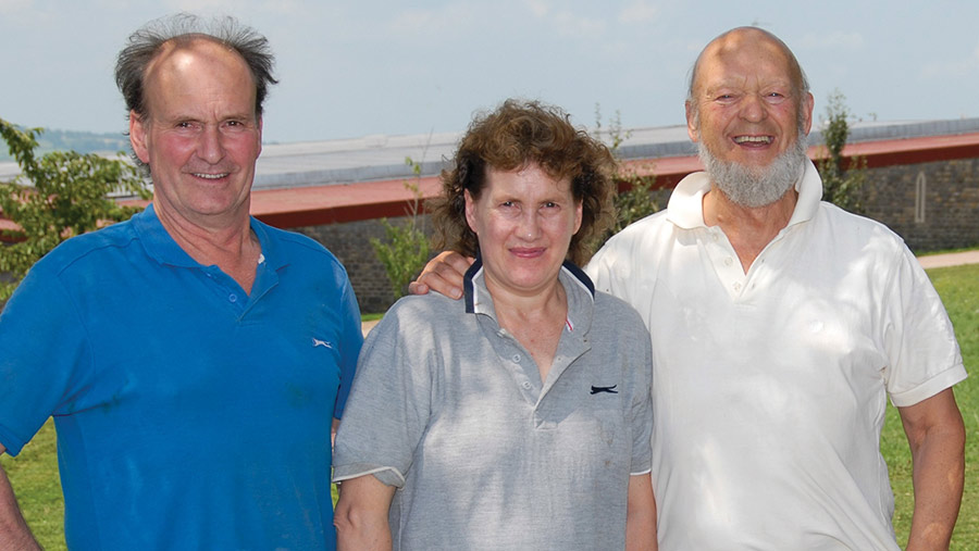 Three people in front of a field