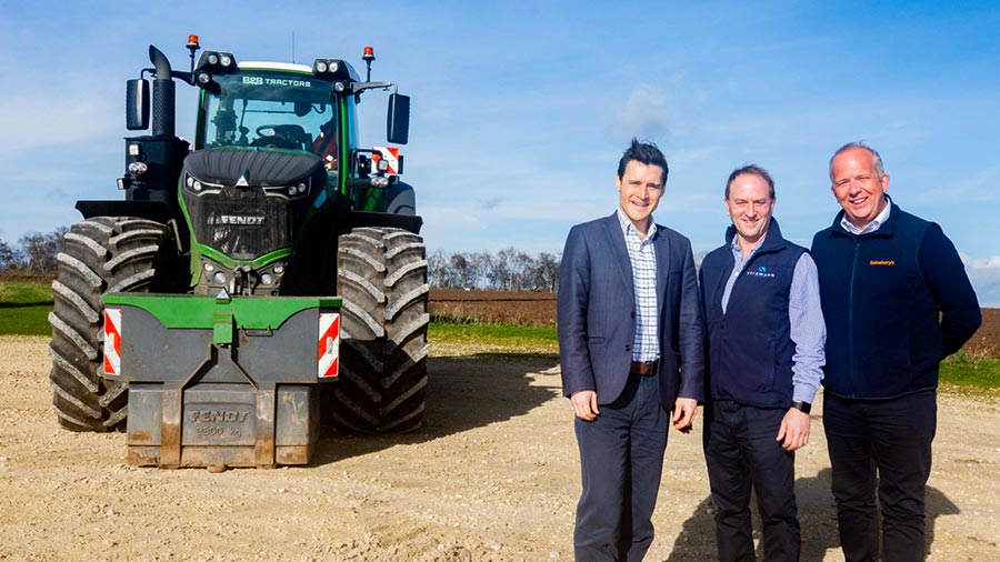 Conservative MP Luke Evans and farmer Mark Strawson standing in front of a tractor