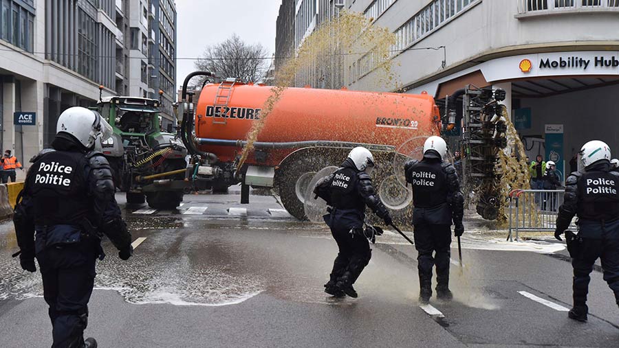 Farmers spray police with manure in Brussels © AP Photo/Harry Nakos