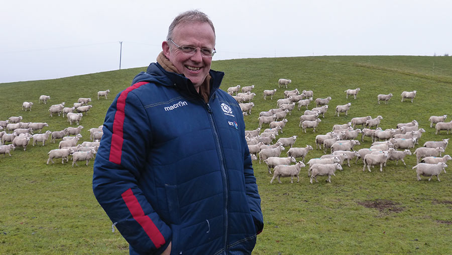 Michael Blanche with flock of sheep in the background