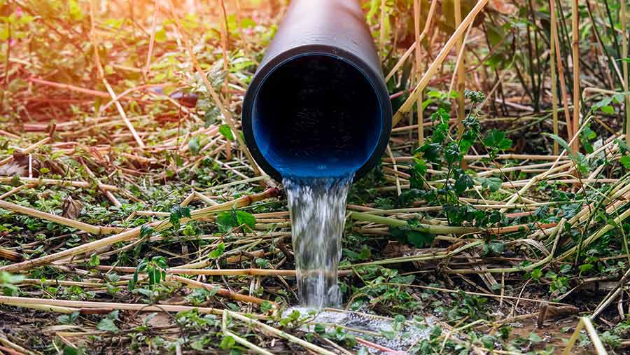 Pipe with water flowing onto the ground