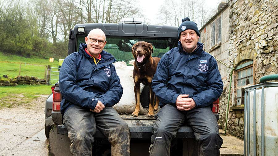 Farmers David and Mat Roberts with dog sitting on a truck