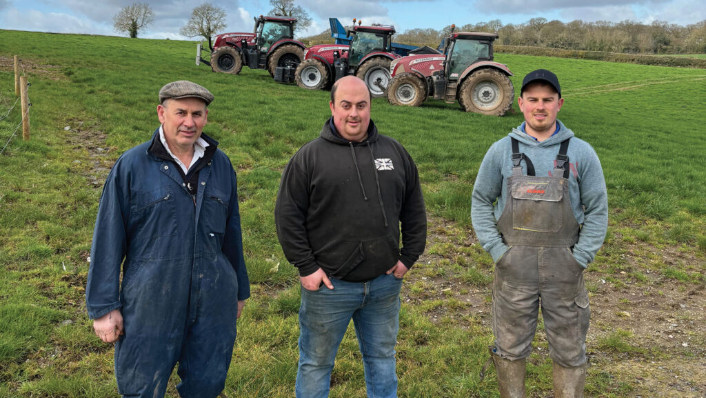Richard, Tom and Henry Leedham in a field, standing in front of McCormick tractors