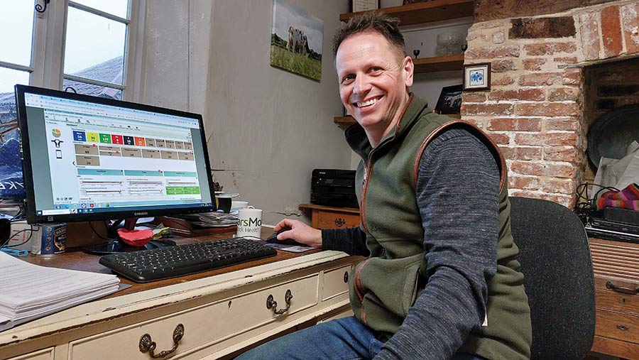 Stuart Rogers in farm office, sitting at a desk and computer