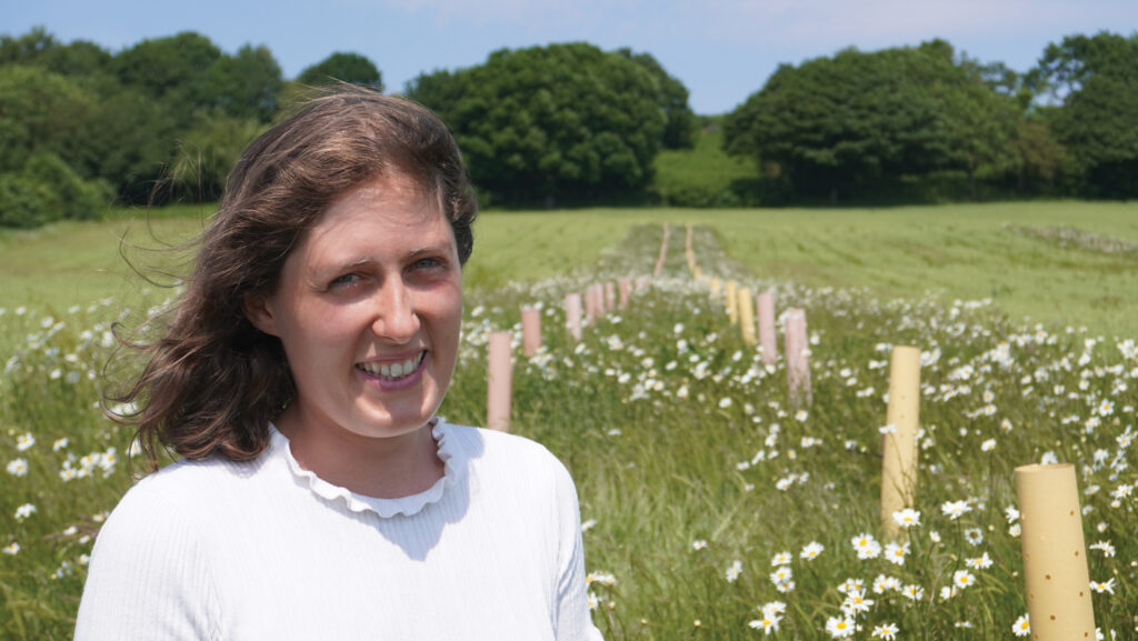 Hannah Fraser in a field with young trees