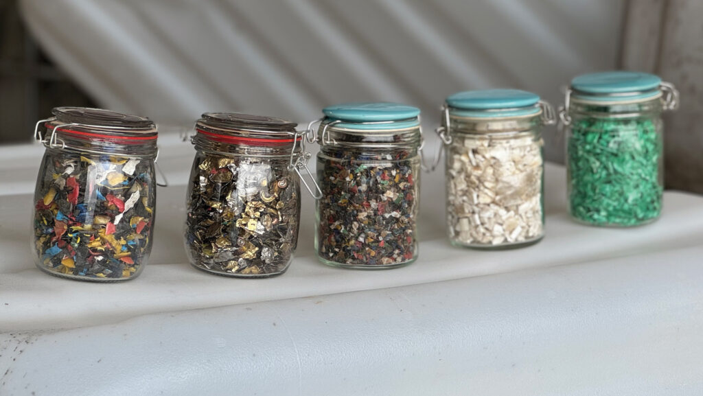Jars filled with different shredded plastics