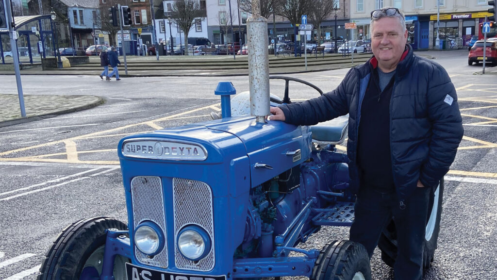 Robert Wilson with vintage tractor in the street