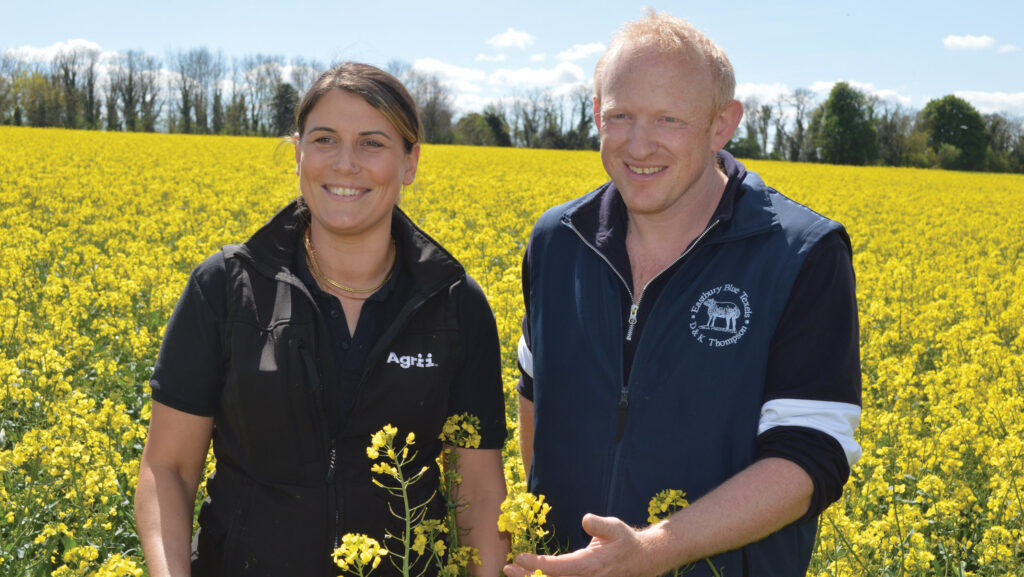 Agronomist Jazz Jex and farmer David Thompson in a field of flowering oilseed rape