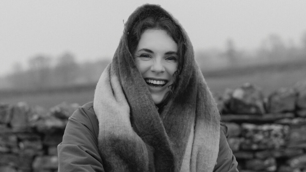 Woman smiling outside with a scarf on her head