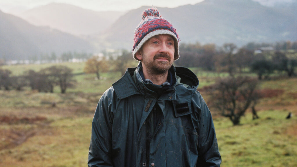 Farmer standing in a misty landscape