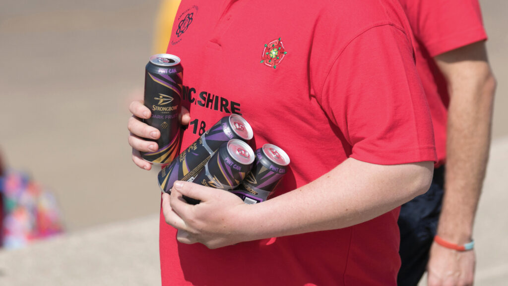 young man carrying beer cans