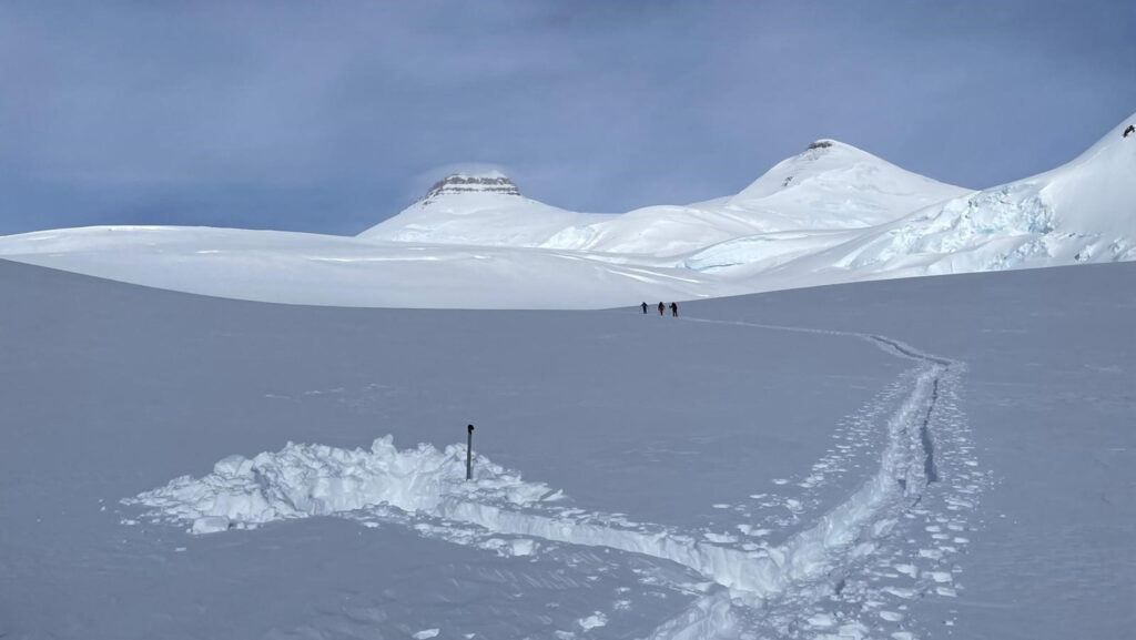 Skiers walking towards the summit