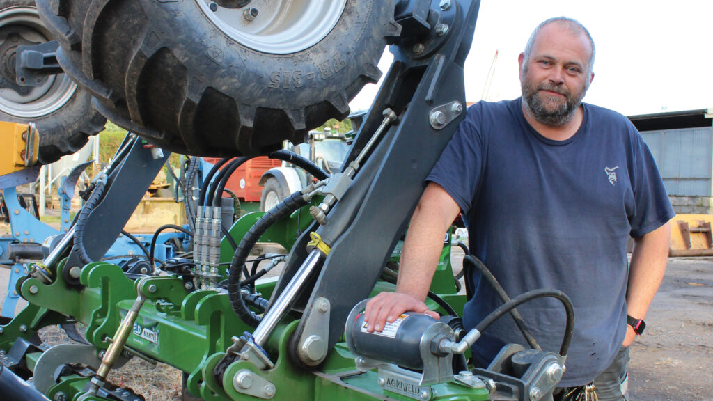 Andrew Sommerville standing beside folded cultivator