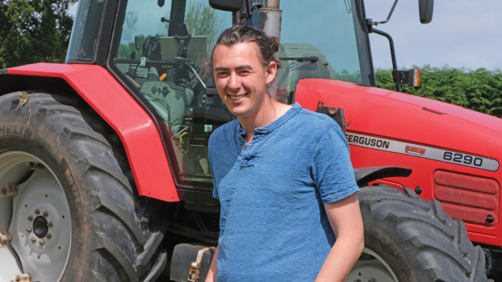 Charles Quick standing by tractor