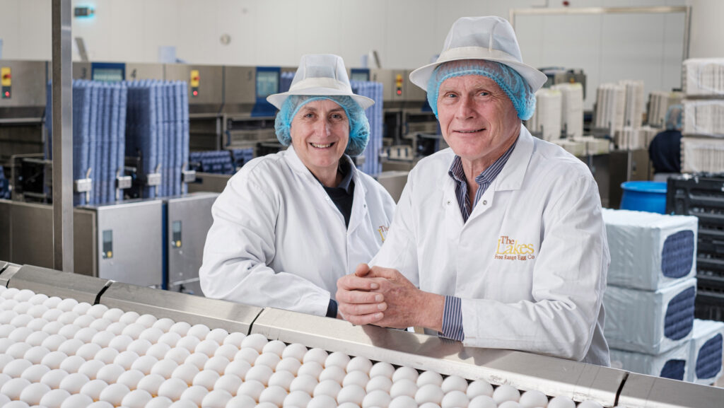 David and Helen Brass, Poultry finalists Farmers Weekly 2024, wearing food-safe overalls and hats in an egg factory