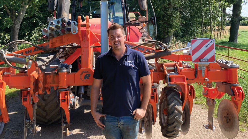 Josh Swiers standing in front of cultivator