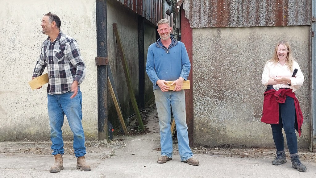 Three people in front of barn, Matt House in middle