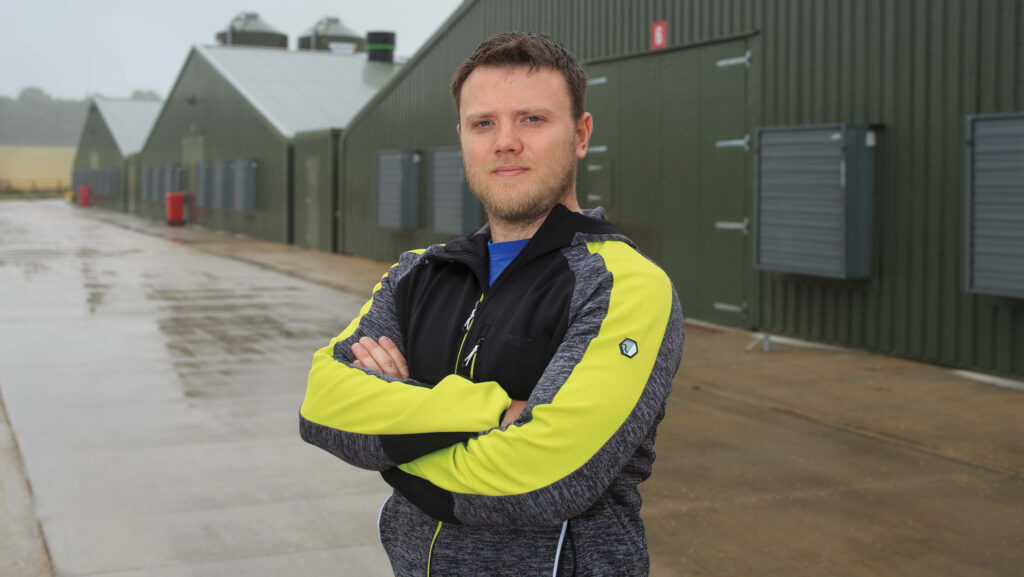 Ryan Wright, Farmers Weekly Awards 2024 Poultry finalist, standing in a farm yard